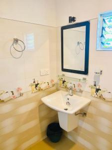 Un baño con un lavabo blanco y un espejo. en Hiriketiya Lima Homestay, en Dikwella 31 fotos más