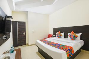 Un dormitorio con una cama grande y un televisor. en FabHotel Red Ark Inn, en Lāndrān