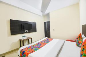 Un dormitorio con una cama y un televisor de pantalla plana. en FabHotel Red Ark Inn, en Lāndrān