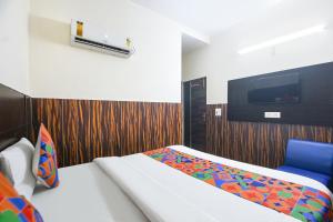 Un dormitorio con una cama y un televisor en la pared. en FabHotel Red Ark Inn, en Lāndrān 15 fotos más