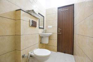 un baño con inodoro y lavabo en FabHotel Red Ark Inn, en Lāndrān