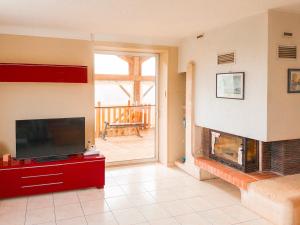 ein Wohnzimmer mit einem TV und einem Kamin in der Unterkunft Maison 8 personnes proche Parc in Montournais