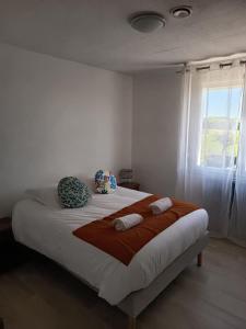 ein Schlafzimmer mit einem Bett mit zwei Kissen und einem Fenster in der Unterkunft Maison 8 personnes proche Parc in Montournais