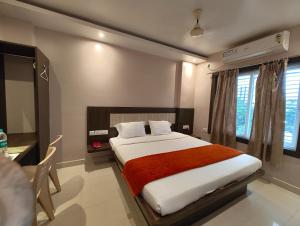 Un dormitorio con una cama, un escritorio y una ventana. en Hotel HTN Stay Puri Near Golden Beach and Temple - Air-Conditioned With Lift #wi-fi And Parking Facilities - Spacious Room - Prime Location Book It Early, en Puri 16 fotos más