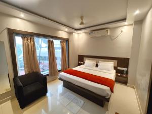 Un dormitorio con una cama, una silla y una ventana en Hotel HTN Stay Puri Near Golden Beach and Temple - Air-Conditioned With Lift #wi-fi And Parking Facilities - Spacious Room - Prime Location Book It Early, en Puri