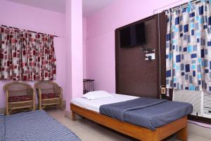 a bedroom with a bed and a flat screen tv at Hotel Hill View in Jamshedpur