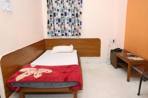 una habitación pequeña con una cama y un escritorio en Hotel Hill View, en Jamshedpur 10 fotos más