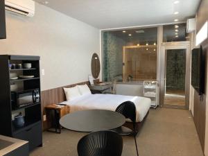 a hotel room with a bed and a table and a sink at クリスタルパーク久松 in Miyako-jima +18 photos