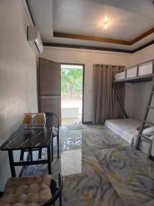 a room with a table and a bunk bed at correashomestay in Coron