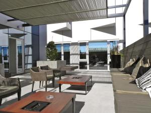 a patio with furniture and tables on a building at Alto del Sol Latorre Mejillones in Mejillones