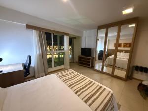 a hotel room with a bed and a large window at Saint Moritz Hotel - ALM Hospedagens - Flat Particular in Brasilia