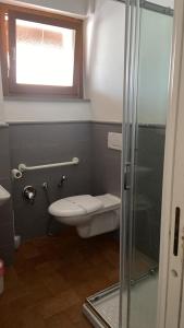 a bathroom with a toilet and a glass shower at La Scuderia in Sarzana +33 photos