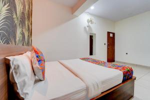 a bedroom with a bed with white walls at FabHotel NRM Residency in Mysore