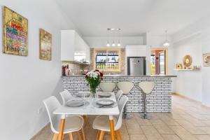 Aphrodite Gardens Apartment by Ezoria Villas في Nea Paphos: غرفة طعام مع طاولة بيضاء وكراسي