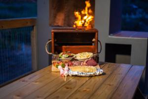 Una mesa con una bandeja de comida sobre una mesa con chimenea. en AfriCamps at Karoo 1, en De Doorns