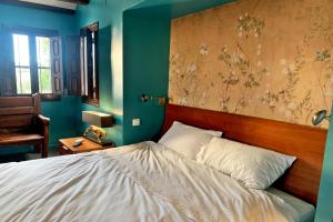 a bedroom with a bed and a wall with a painting at La Cortijera in Benidoleig +30 photos