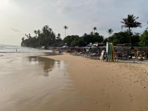 een strand met stoelen en parasols en de oceaan bij Haru Ahangama in Ahangama