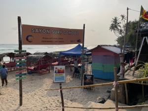 een zandstrand met een bord op het strand bij Haru Ahangama in Ahangama +3 foto's