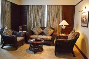 a living room with a couch and two chairs at Waterfront Airport Hotel and Casino in Mactan