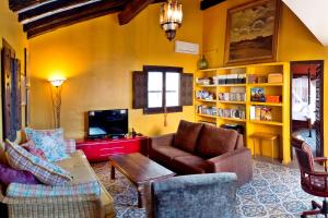 a living room with a couch and chairs and a tv at La Cortijera in Benidoleig