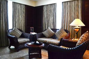 a living room with couches and chairs and a table at Waterfront Airport Hotel and Casino in Mactan