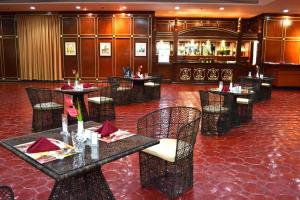 a restaurant with tables and chairs and a bar at Waterfront Airport Hotel and Casino in Mactan