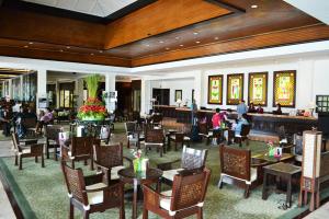 a restaurant with tables and chairs and a bar at Waterfront Airport Hotel and Casino in Mactan