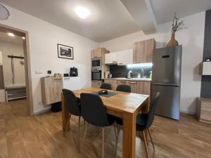 a kitchen and dining room with a wooden table and chairs at Apartmán Mařinka in Říčky