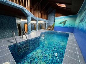 a swimming pool in a house with an aquarium at Гостинний двір "Марія" in Kropyvnytskyi