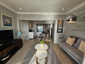 a living room with a couch and a table at Induli on Sage in Plattekloof