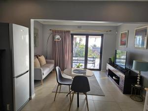 a living room with a couch and a table at Induli on Sage in Plattekloof