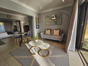 a living room with a couch and a table at Induli on Sage in Plattekloof