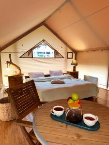 a bedroom with a bed and a table with a tray of fruit at WOW Glamping in Dsegh