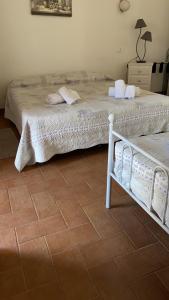 a bedroom with two beds and a tile floor at La Scuderia in Sarzana
