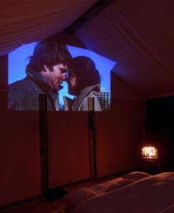 a room with a large screen with a man and a woman at WOW Glamping in Dsegh +63 photos