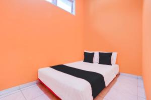 um quarto com uma cama com uma parede laranja em Hotel O Green House em Yogyakarta