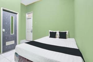 um quarto com uma cama grande com paredes verdes em Hotel O Green House em Yogyakarta mais 26 fotografias