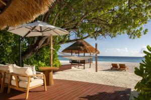 Una playa con sillas y sombrillas y el océano. en Banyan Tree Vabbinfaru, en Male 108 fotos más