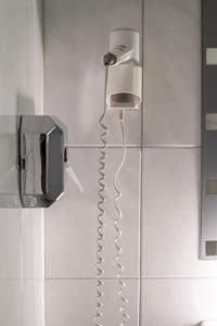 a phone hanging on a wall in a bathroom at Villa Diana WestEnd in Frankfurt +190 photos