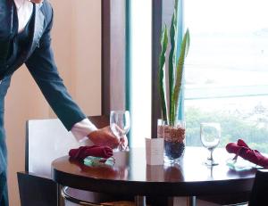 a person standing over a table with wine glasses at Waterfront Airport Hotel and Casino in Mactan
