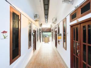 a hallway with white walls and wooden doors at Tiny House Gianyar RedPartner in Gianyar +12 photos