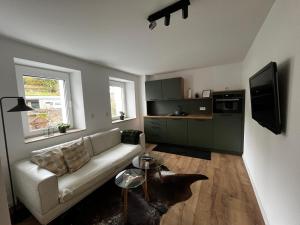 a living room with a white couch and a kitchen at Ferienwohnung Martha und Nikla in Philippsheim
