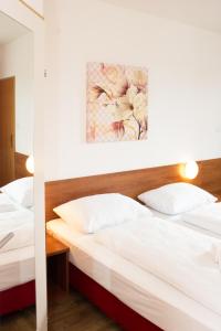 Ένα ή περισσότερα κρεβάτια σε δωμάτιο στο OEKOTEL Traiskirchen