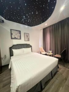 a bedroom with a large bed with a star ceiling at Boutique Hotel in Hanoi