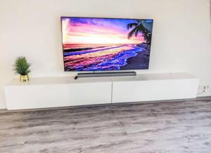 einen Flachbild-TV auf einem weißen Schrank in der Unterkunft Ferienwohnung Sonnenschein in Bad Pyrmont