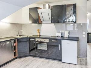 eine Küche mit schwarz-weißen Schränken und einer Spüle in der Unterkunft Ferienwohnung Sonnenschein in Bad Pyrmont + 8 Fotos