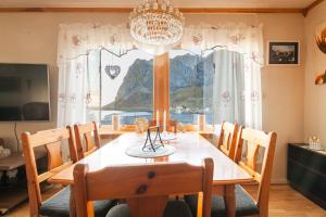 a dining room with a table and a large window at Valen Retro Home, Reine in Reine