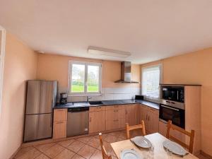 une cuisine avec des appareils en acier inoxydable et une table dans l'établissement Grande maison 5 chambres 25 min du Parc, à Chavagnes-les-Redoux 29 autres photos