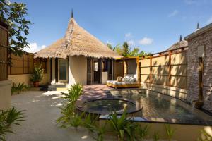 Una villa con piscina y un edificio. en Banyan Tree Vabbinfaru, en Male