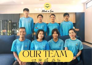 a group of men and women in blue shirts holding a sign at Palm Villa - Spacious 4 Bedrooms with Private Pool in Rawai Beach +52 photos